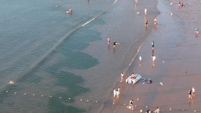 航拍夏季海滩上嬉水的游客