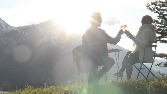 徒步旅行的夫妇在山腰的桌子上享受普罗赛科