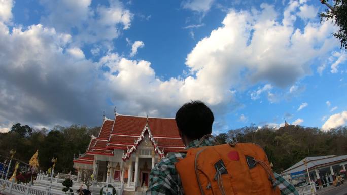 一名男性游客探索泰国寺庙的后视图。