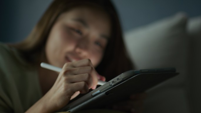 亚洲女性在数码平板电脑上绘制连衣裙