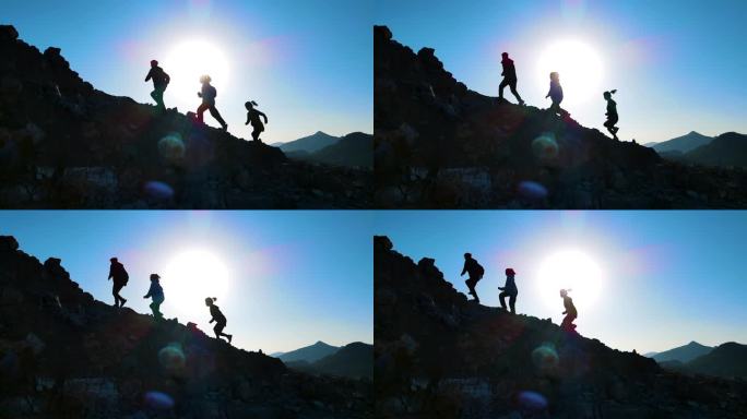 团队冲向山顶户外探险人物剪影逆光登山爬山