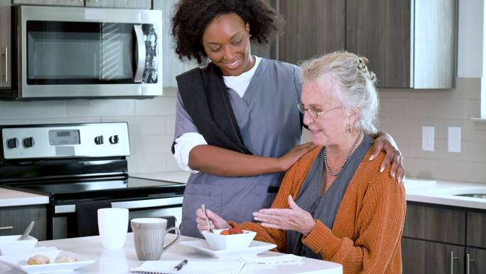 家庭护理员帮助老年妇女吃健康零食
