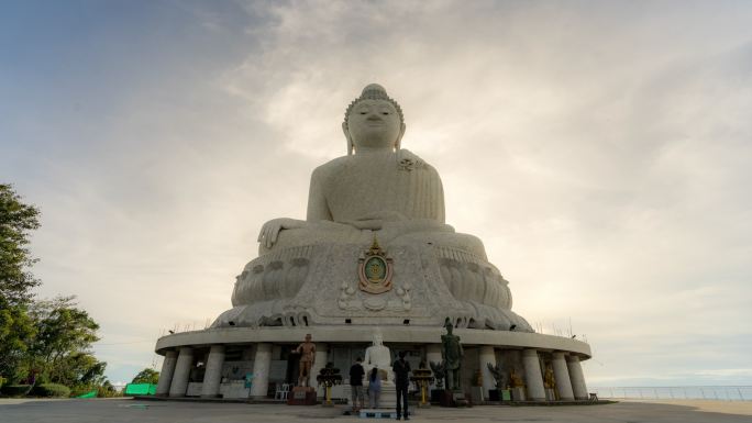 时间流逝在泰国普吉岛上的普吉岛大佛纪念碑上欣赏壮观的日落。钢筋混凝土结构装饰着来自缅甸的白玉大理石S