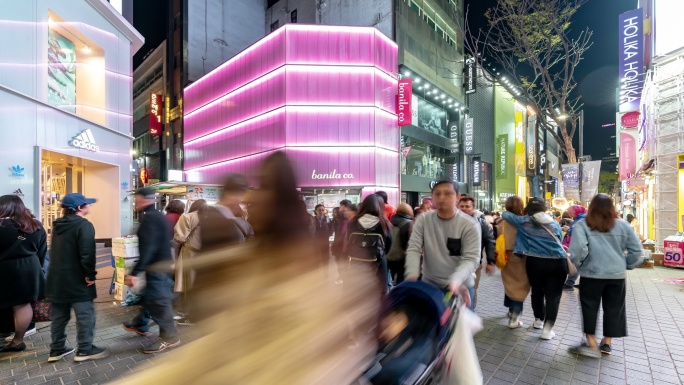 时间流逝：韩国首尔明洞市中心购物街夜晚的行人