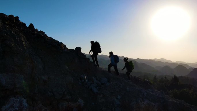 一群人爬上山顶团队登山脚步成功登顶旅行者