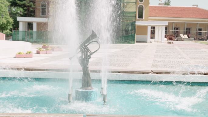 喇叭音乐和水。受音乐启发的城市喷泉的细节。乐器上方流水的特写镜头。城市场景。公共公园。城市生活