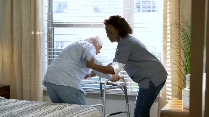 家庭保健工作者帮助老年人使用助行器
