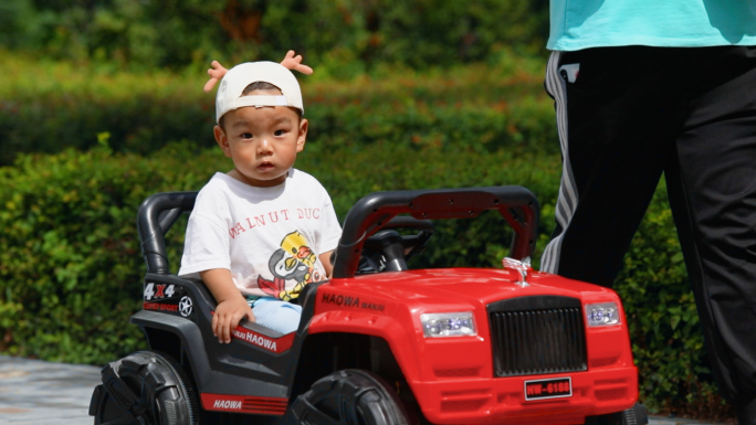 小区社区可爱小孩乘坐儿童电动玩具车