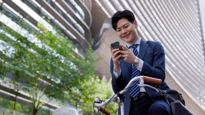 骑自行车上下班的漂亮年轻人看手机