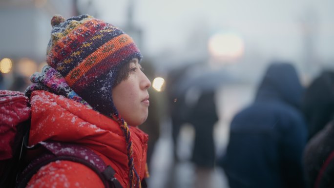 冬天在城市红绿灯前等待的年轻女性旅行者