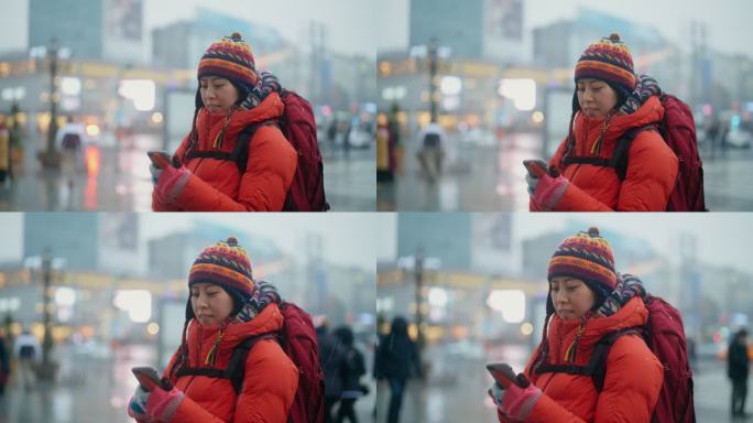 冬季在城市使用智能手机的女性旅行者