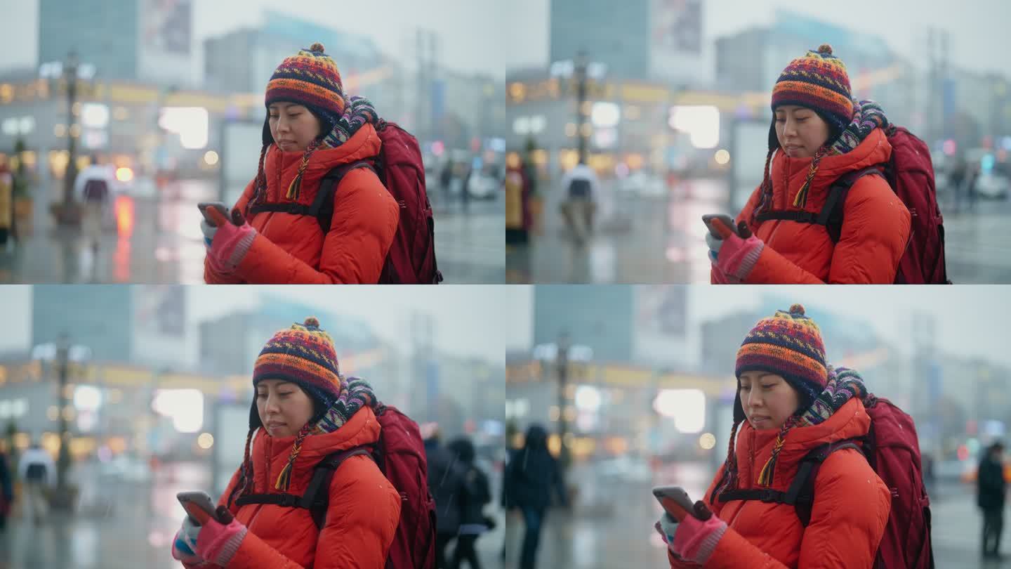 冬季在城市使用智能手机的女性旅行者