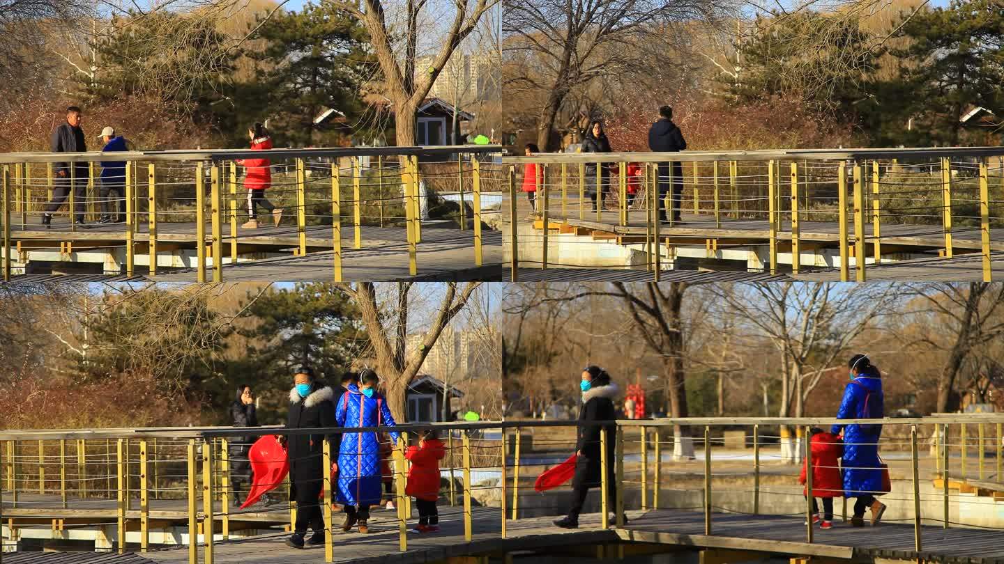 冬季公园大人小孩游客从一处桥上走过实拍
