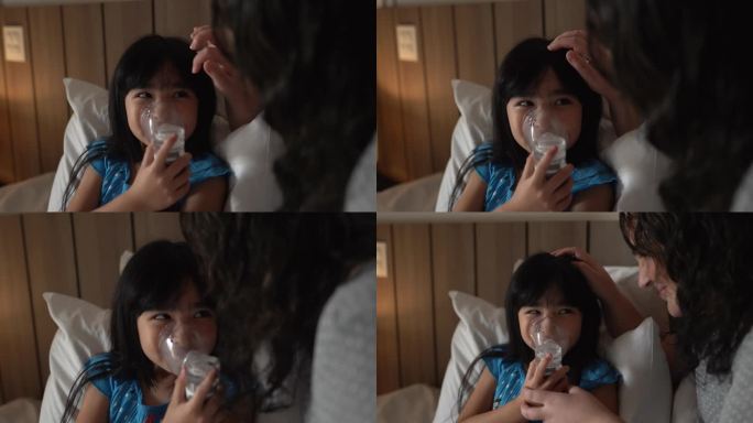 母亲在家中的床上帮助女儿使用喷雾器进行吸入治疗