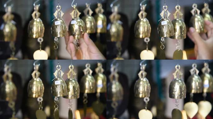 泰国一名女游客在纪念品商店挑选铃铛。