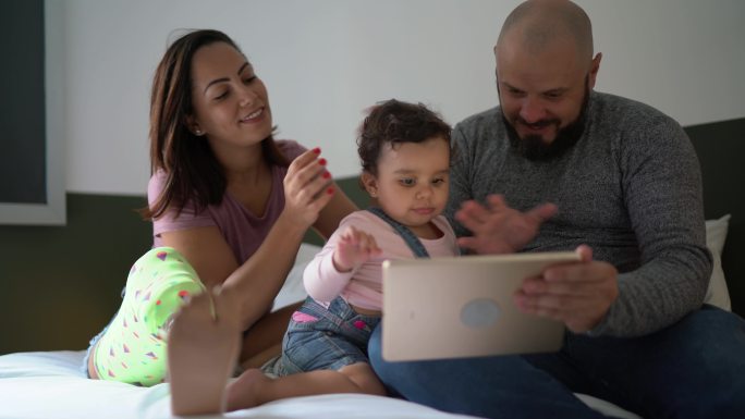 家人在家里的床上用数字平板电脑观看电影-包括一名残疾妇女