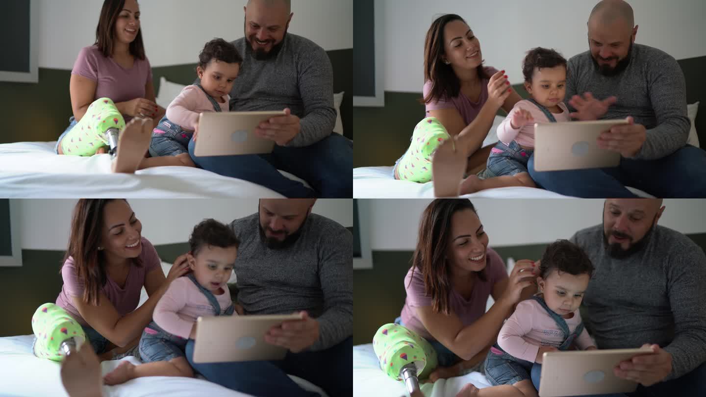 家人在家里的床上用数字平板电脑观看电影-包括一名残疾妇女