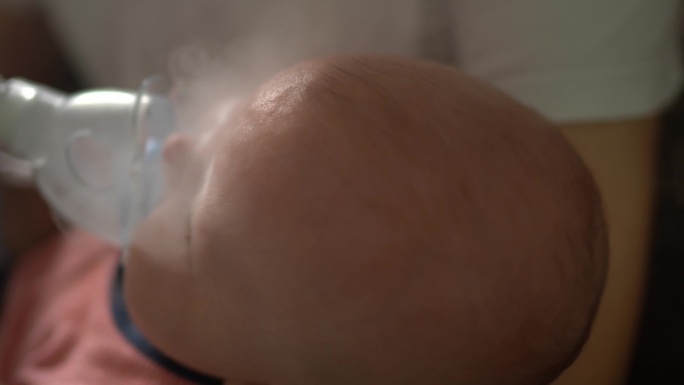 使用吸入器面罩的男婴吸入疗法