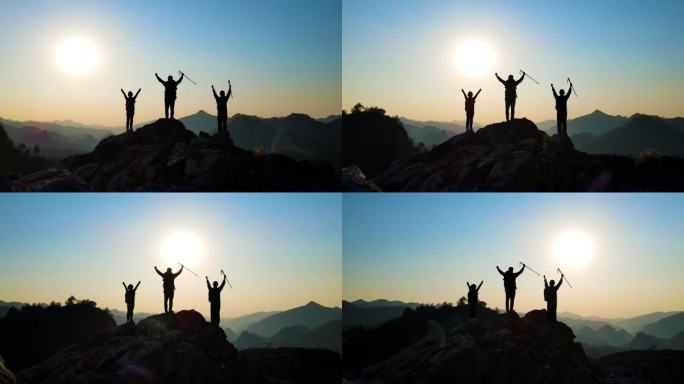 团队登山背影站在山巅举手欢呼团队精神爬山