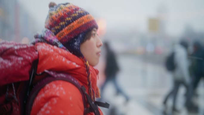 年轻的女性旅行者在冬天在城市里观光和过马路