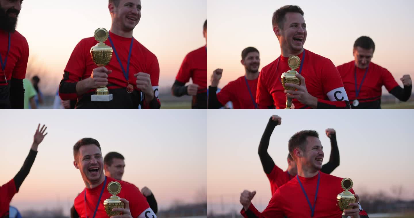 兴奋的足球运动员在赢得奖杯后一起庆祝