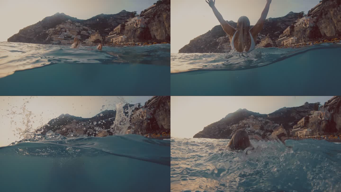 SLO MO一名女子在著名村庄Positano的海湾游泳时，双臂向上举起，跳跃