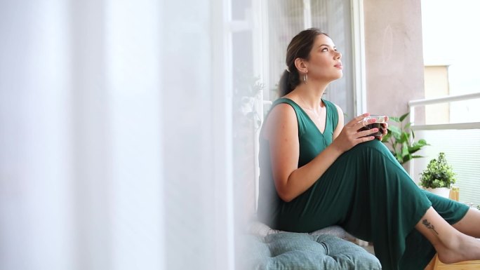 年轻女人在露台上喝咖啡