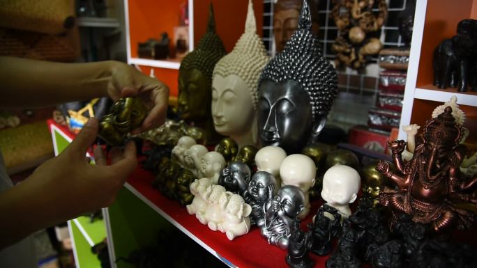 泰国一名女游客在纪念品商店挑选纪念品。