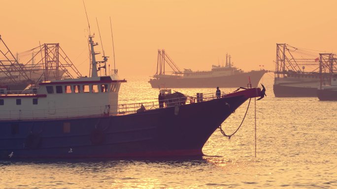 夕阳下海边海港货船停泊驳船北海市北部湾号