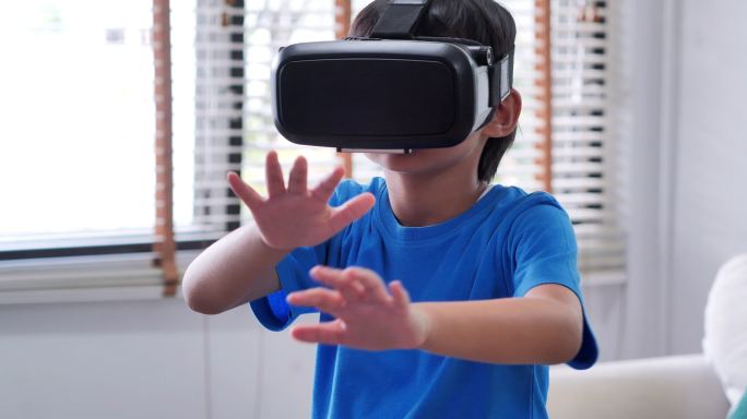 戴着虚拟现实护目镜的男孩。孩子们正在体验虚拟现实。惊讶的小男孩戴着VR眼镜。教育、儿童、技术、科学和