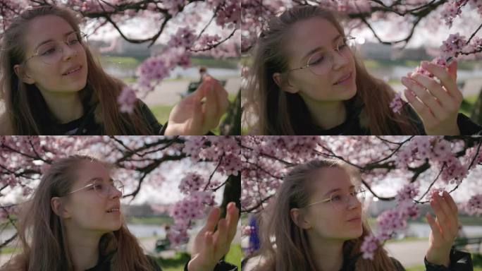 少女在美丽的樱花树上欣赏春天的花朵