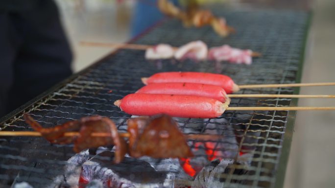 一群人围在火炭炉前烧烤，烧烤各种食材