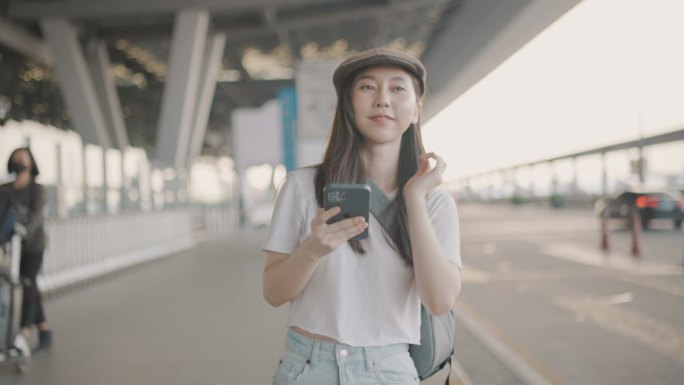 女游客在机场用智能手机叫出租车。