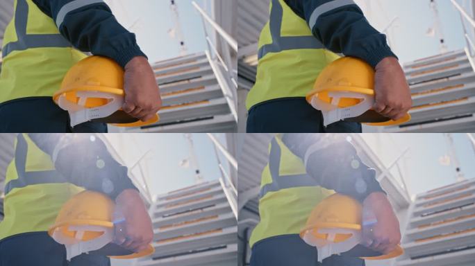 特写一名轮机员和承包商从下面举着黄色安全防护帽在海上货船上工作。技术人员和维修技工准备好在船坞维修问