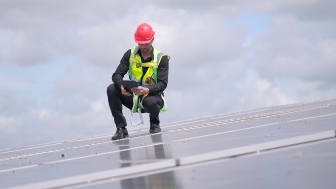 闭合。专家工程师或承包商检查项目进度，并在建筑屋顶的太阳能发电厂安装太阳能电池板。可再生能源概念，工