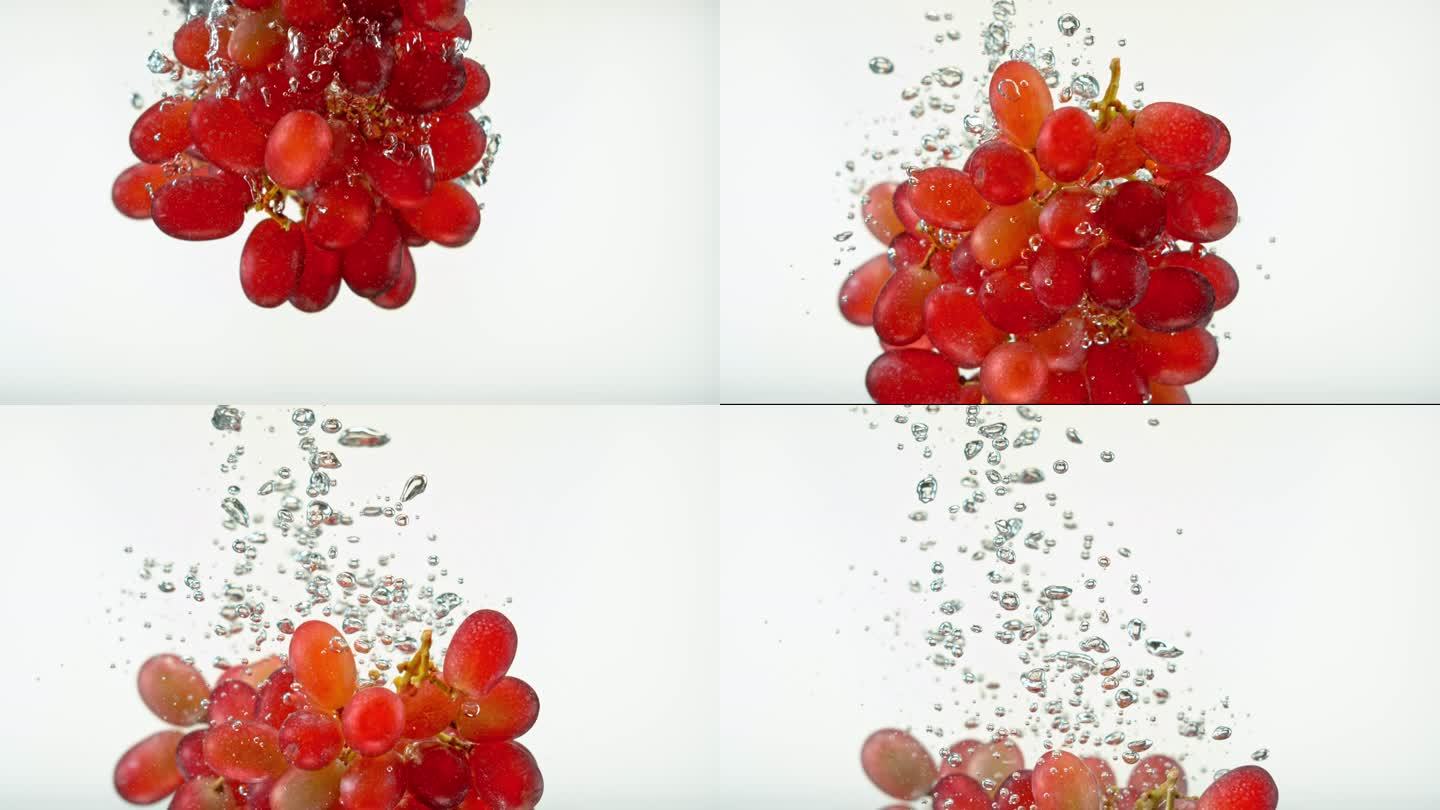 SLO MO LD白色背景下落在水中的红葡萄集群