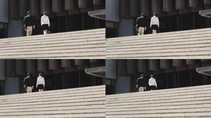 在城市背景下，一名商人和女商人走上一段楼梯的4k视频片段