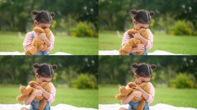 小女孩在花园里玩泰迪熊