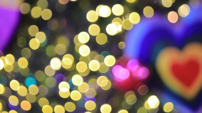 圣诞树上模糊的灯光庆祝，新年快乐的彩色背景。