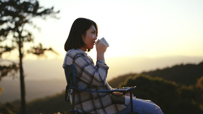 女人在早晨喝咖啡，在大自然中放松