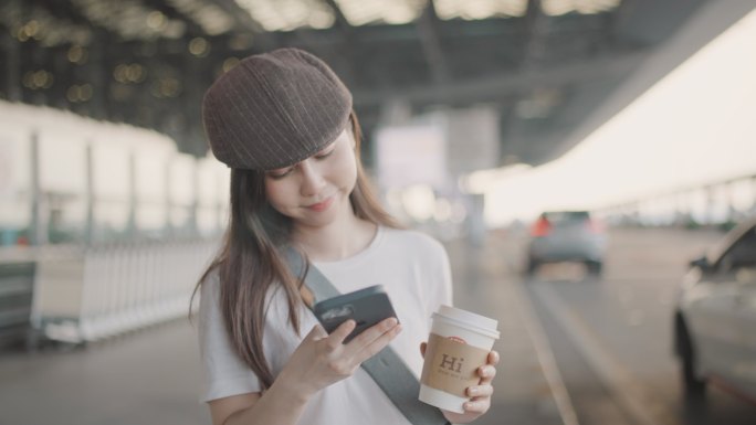 女游客在机场用智能手机叫出租车。