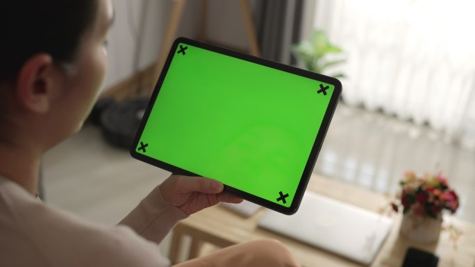 女性在绿色模拟屏幕上使用数字平板电脑