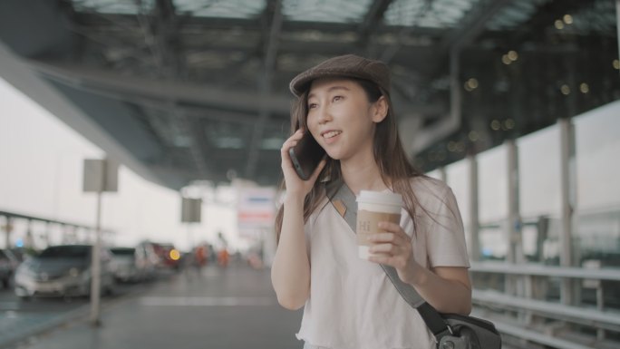 女游客在机场用智能手机叫出租车。