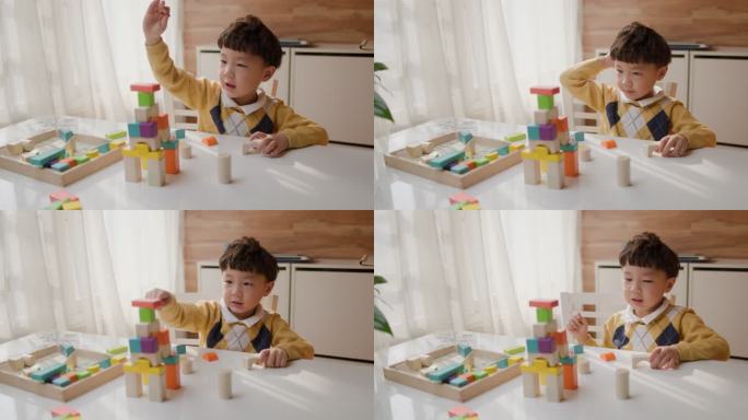 亚洲小男孩在桌子上玩积木