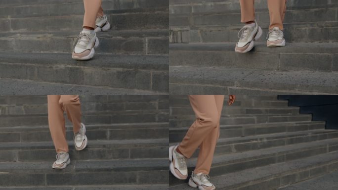 女性脚穿着现代白色运动鞋下楼梯