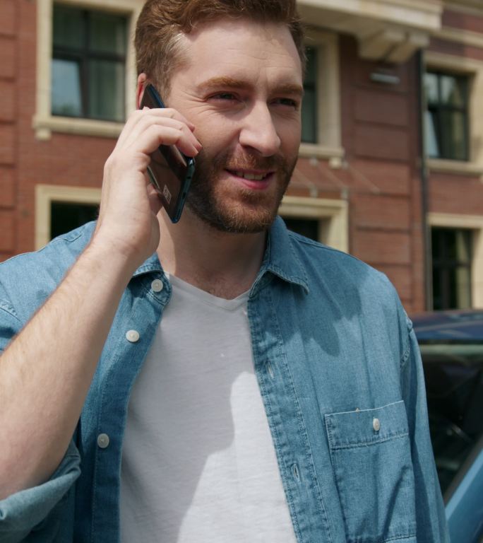 一位汽车推销员结束了电话交谈，微笑着把电话放进了口袋