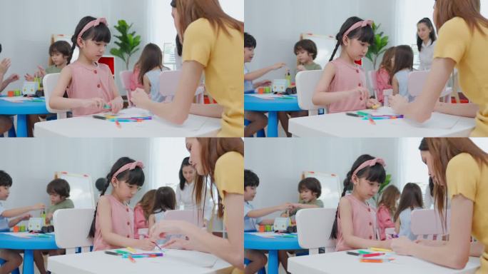 亚洲美丽的年轻女教师在学校给孩子上课。吸引人的女教师大师在幼儿园的课堂上用有趣的活动向孩子们讲解和教