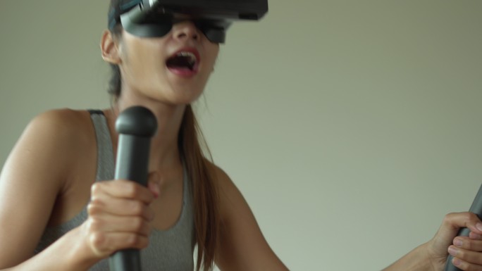 在家中使用椭圆机佩戴虚拟现实护目镜的女性