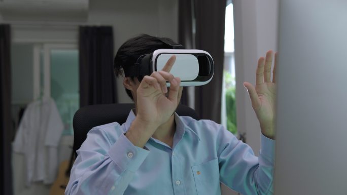 亚洲男子戴着虚拟现实眼镜耳机在家里触摸空气
