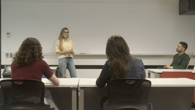 女大学生在课堂上向不同群体的成年青年学生展示